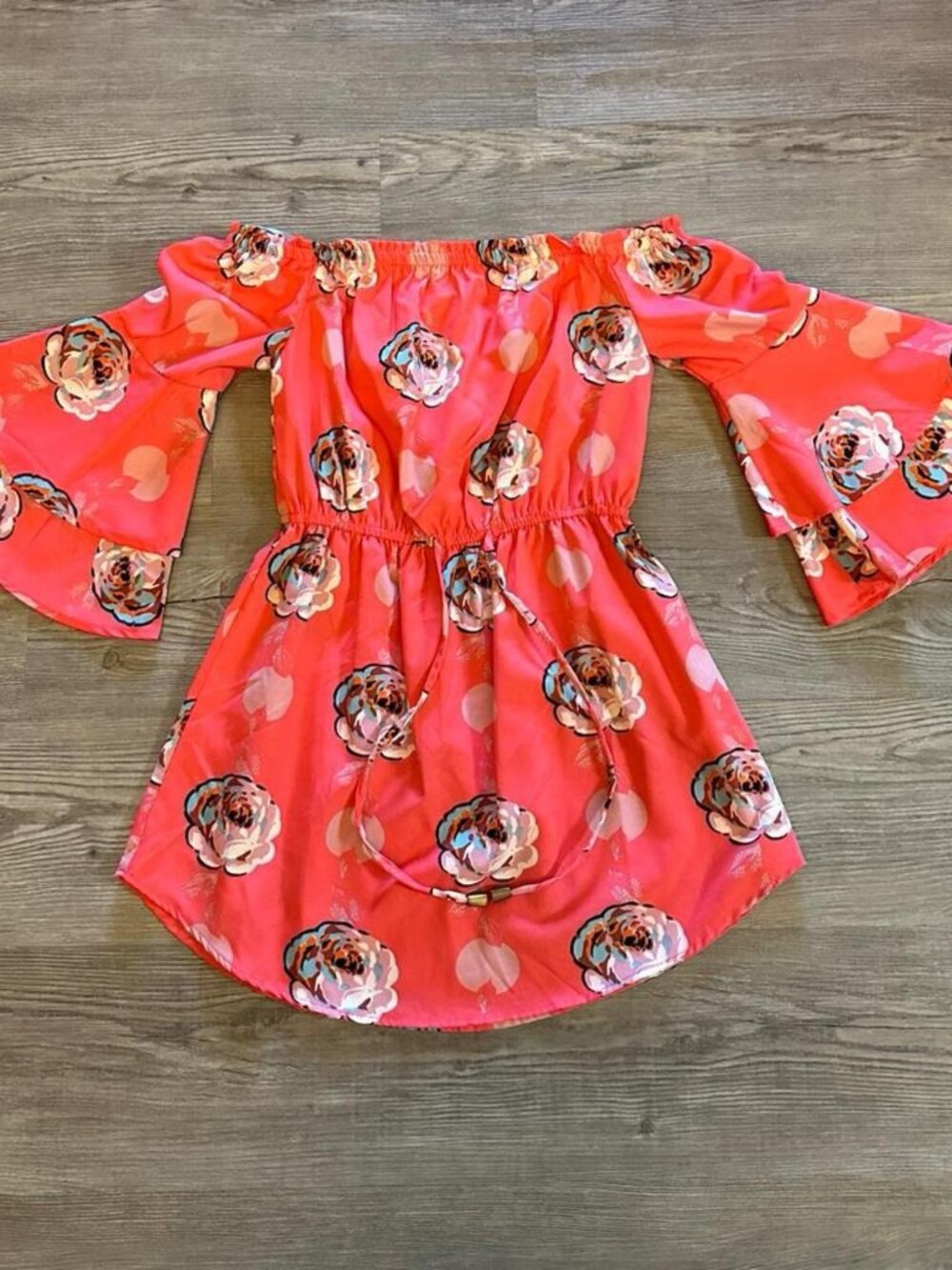 Salmon color floral off-the-shoulder mini dress with bell sleeves and tie waist.